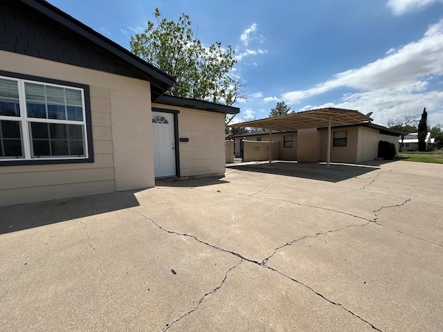 back of property featuring driveway and a carport