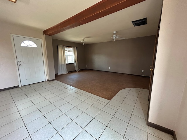 foyer featuring light colored carpet, baseboards, ceiling fan, and light tile patterned floors