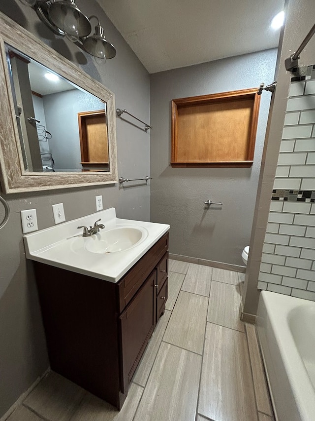 full bath with toilet, wood finish floors, and vanity