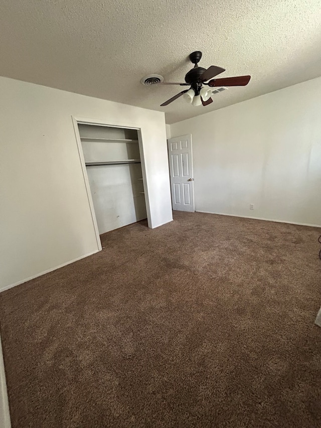 unfurnished bedroom featuring a ceiling fan, a textured ceiling, carpet, and a closet