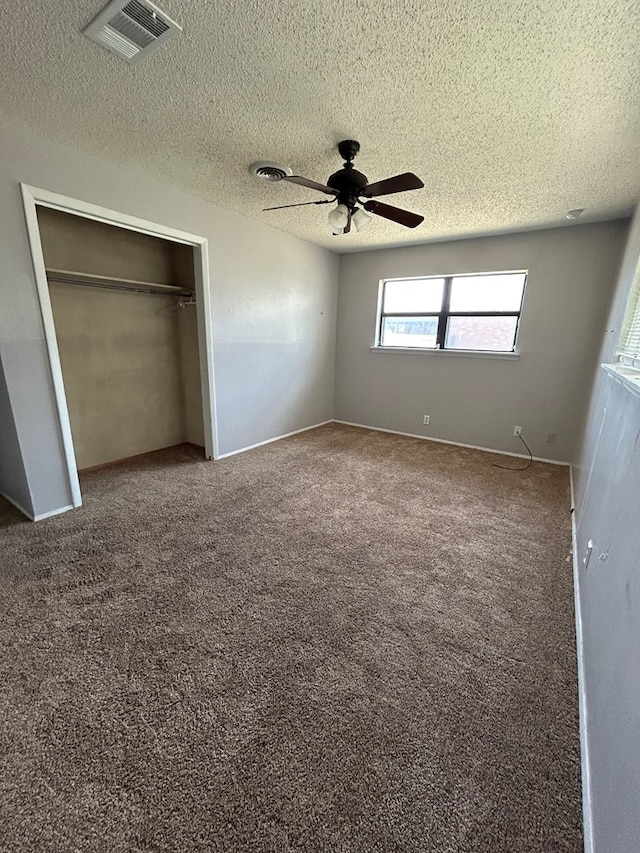 unfurnished bedroom with carpet floors, a textured ceiling, and visible vents