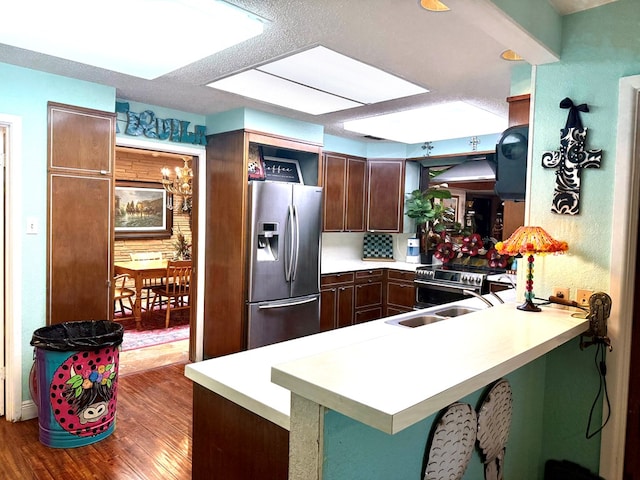 2500 Bainbridge Dr, Odessa, TX 79762 - kitchen featuring stainless steel appliances, wood finished floors, a peninsula, and light countertops