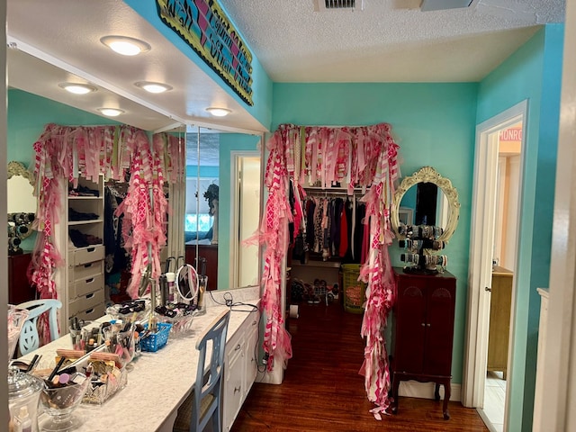 2500 Bainbridge Dr, Odessa, TX 79762 - bathroom featuring wood finished floors, a walk in closet, vanity, and a textured ceiling