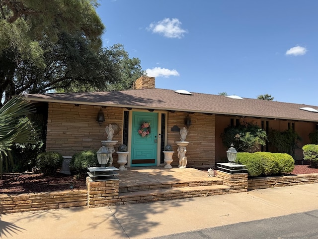2500 Bainbridge Dr, Odessa, TX 79762 - view of front of home featuring a chimney, stone siding, and a shingled roof