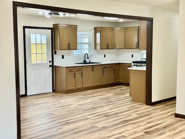2816 Catalina Dr, Odessa, TX 79764 - kitchen featuring light wood-style floors, decorative backsplash, light countertops, and stainless steel gas stove