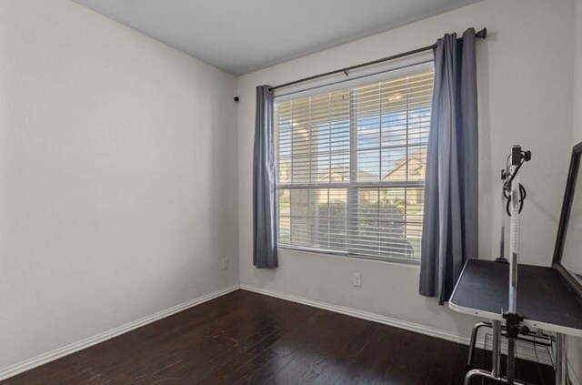7012 Perot Ranch Rd, Odessa, TX 79765 - unfurnished room with healthy amount of natural light, dark wood-style floors, and baseboards