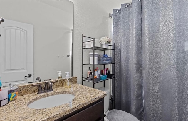 7012 Perot Ranch Rd, Odessa, TX 79765 - full bath featuring vanity, toilet, a textured wall, and curtained shower