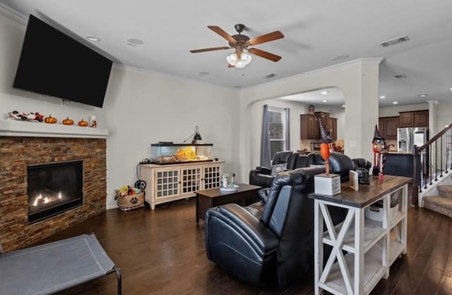 7012 Perot Ranch Rd, Odessa, TX 79765 - living area featuring crown molding, a ceiling fan, dark wood-style floors, a stone fireplace, and stairway