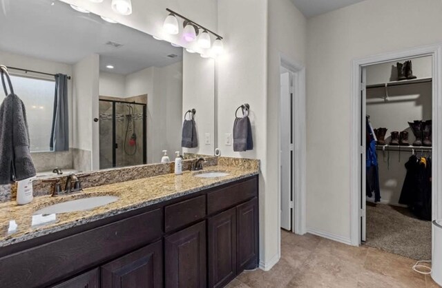 7012 Perot Ranch Rd, Odessa, TX 79765 - bathroom with a shower stall, a walk in closet, double vanity, and baseboards