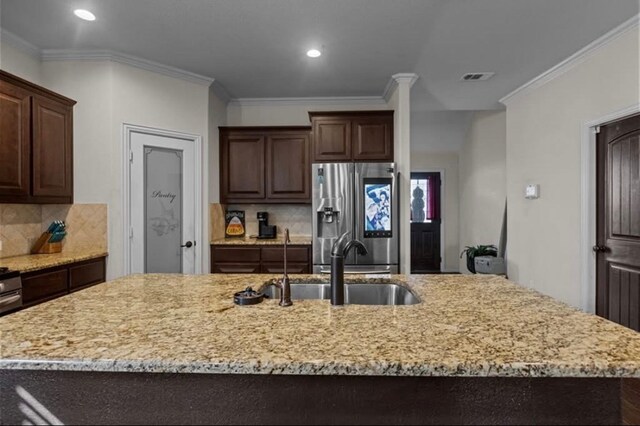 7012 Perot Ranch Rd, Odessa, TX 79765 - kitchen with stainless steel refrigerator with ice dispenser, a sink, recessed lighting, tasteful backsplash, and light stone counters