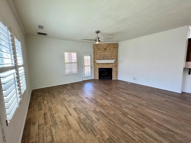 2909 Cagle Ln, Odessa, TX 79762 - unfurnished living room featuring a ceiling fan, ornamental molding, a large fireplace, and wood finished floors