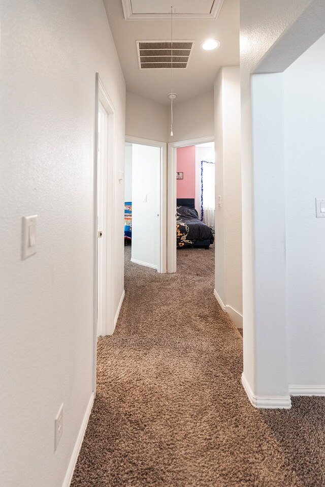 hallway with dark colored carpet