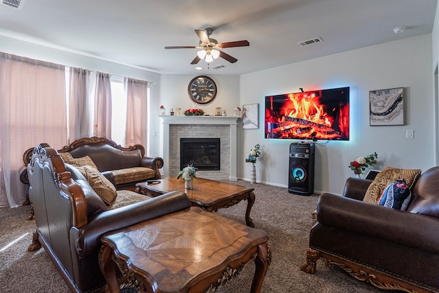 living room featuring carpet, ceiling fan, and a brick fireplace