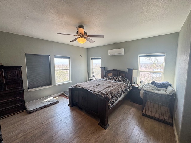 1500 Rancho Rd, Presidio, TX 79845 - bedroom featuring a wall unit AC, wood finished floors, a textured ceiling, ceiling fan, and baseboards