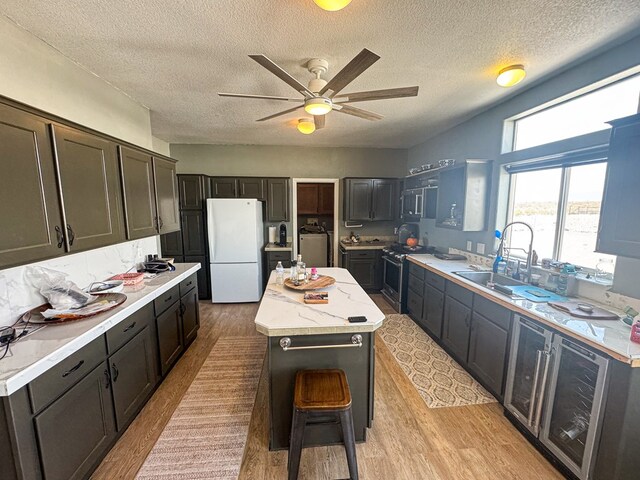 1500 Rancho Rd, Presidio, TX 79845 - kitchen with freestanding refrigerator, gas range, a kitchen island, light countertops, and ceiling fan