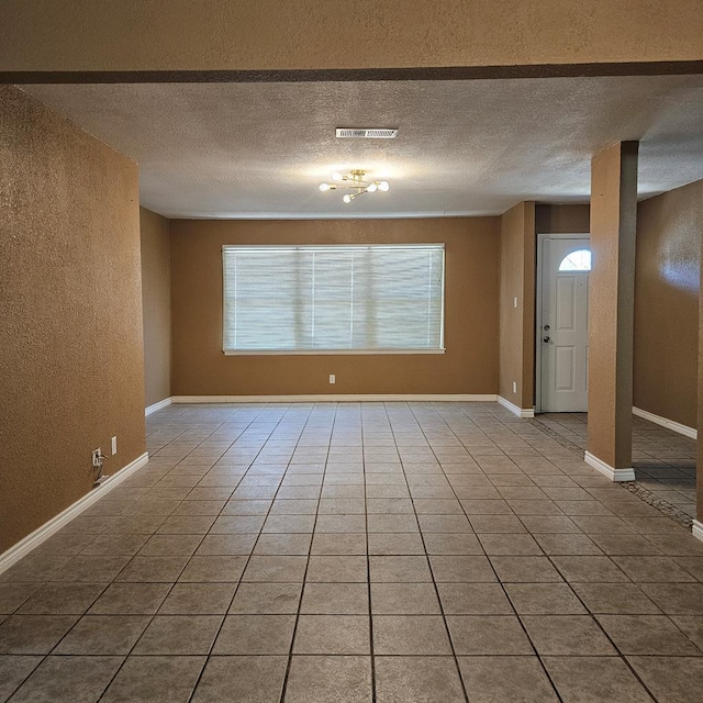 801 W Golf Course Rd, Midland, TX 79701 - unfurnished room featuring a textured wall, a textured ceiling, and tile patterned flooring