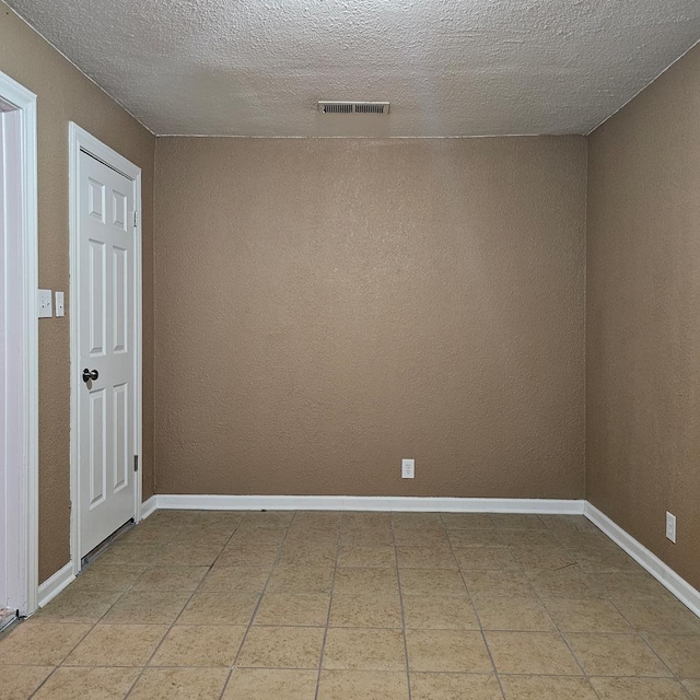 801 W Golf Course Rd, Midland, TX 79701 - spare room featuring a textured ceiling, tile patterned flooring, baseboards, and a textured wall
