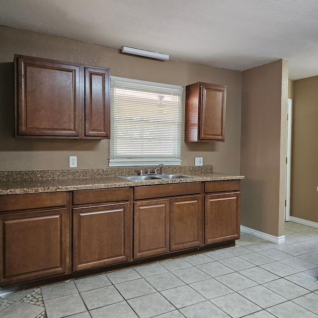 801 W Golf Course Rd, Midland, TX 79701 - kitchen featuring a sink, light tile patterned flooring, and baseboards
