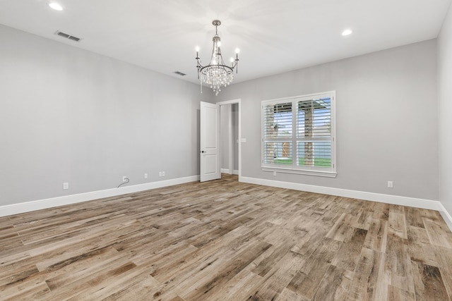 unfurnished room with light wood-style floors, a chandelier, baseboards, and recessed lighting