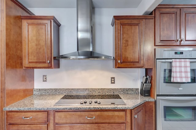 104 E 3rd St, Marfa, TX 79843 - kitchen with wall chimney range hood, brown cabinets, stainless steel double oven, and black electric stovetop