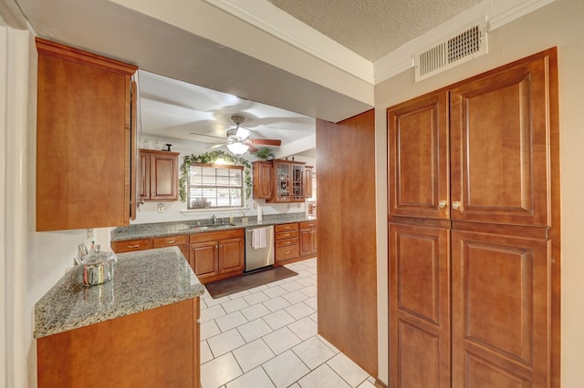 104 E 3rd St, Marfa, TX 79843 - kitchen with stainless steel dishwasher, visible vents, brown cabinets, a sink, and light tile patterned floors