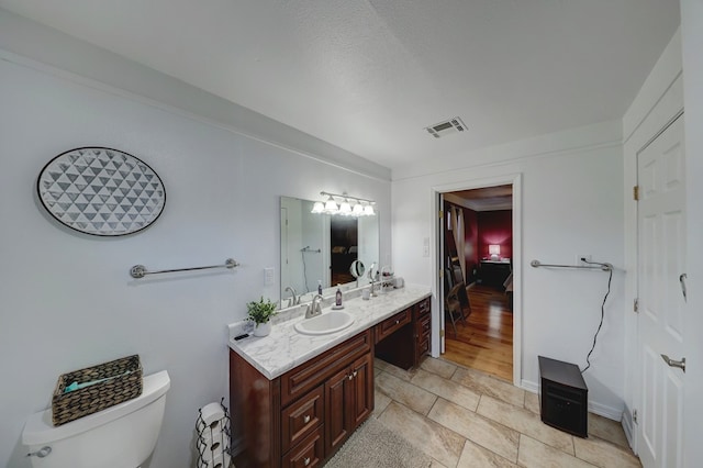 104 E 3rd St, Marfa, TX 79843 - bathroom with vanity, tile patterned flooring, toilet, and visible vents