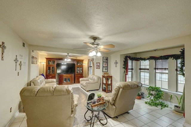 104 E 3rd St, Marfa, TX 79843 - living room featuring ceiling fan, a textured ceiling, visible vents, light tile patterned floors, and baseboards