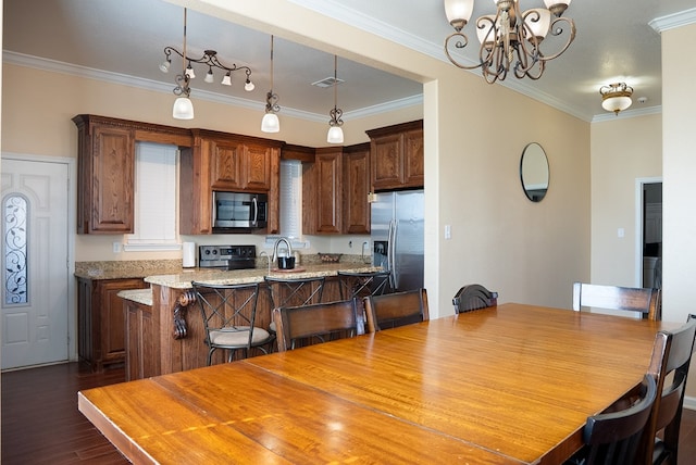 9540 W April St, Odessa, TX 79764 - kitchen featuring appliances with stainless steel finishes, a chandelier, dark wood-style floors, a center island, and ornamental molding