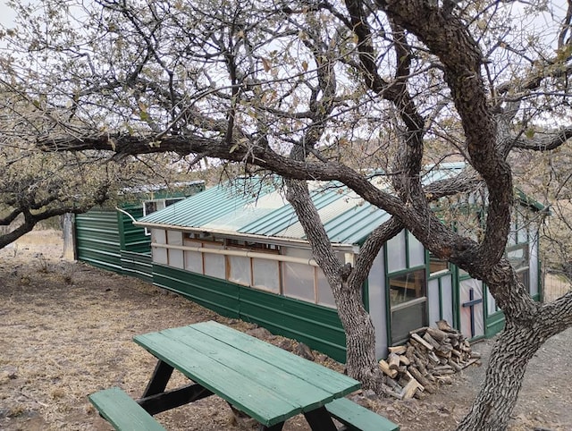 view of side of property with metal roof, an exterior structure, and an outdoor structure