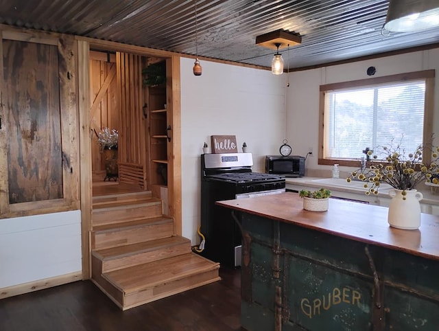 kitchen with wood counters, wooden ceiling, stainless steel range with gas cooktop, and dark wood finished floors