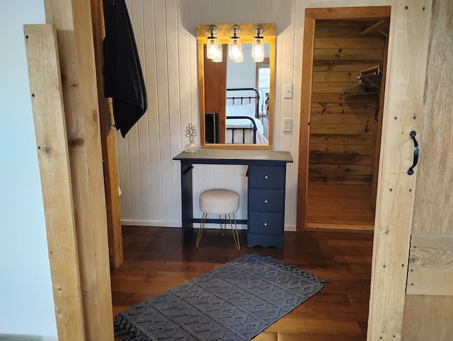 bathroom featuring wood walls, baseboards, and wood finished floors