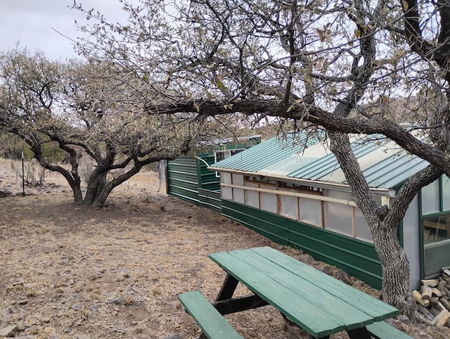 surrounding community featuring a greenhouse and an outdoor structure