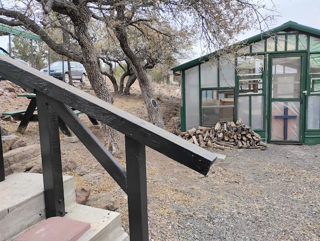 exterior space with a greenhouse and an outdoor structure