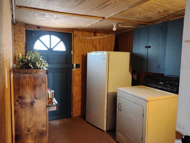 kitchen featuring wooden walls, washer / clothes dryer, light countertops, and freestanding refrigerator