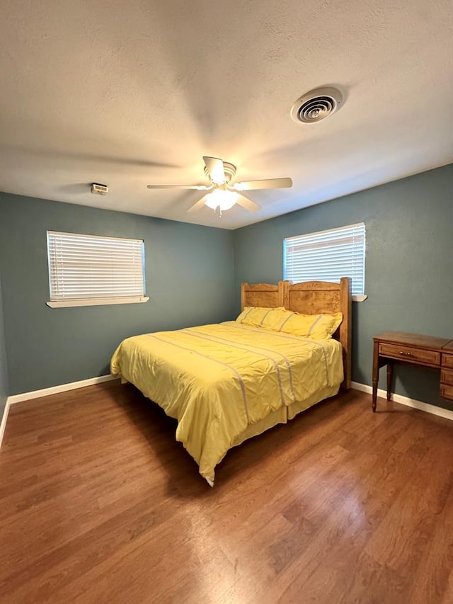 2003 N Enfield Rd, Alpine, TX 79830 - bedroom with baseboards, wood finished floors, a ceiling fan, and a textured ceiling