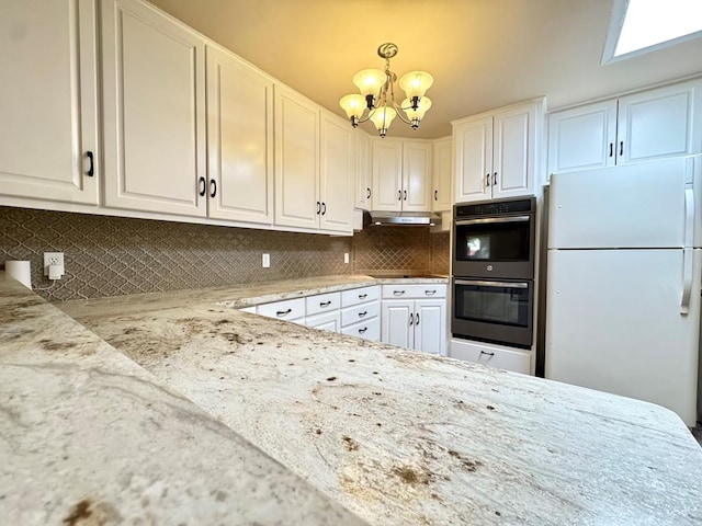 2003 N Enfield Rd, Alpine, TX 79830 - kitchen featuring freestanding refrigerator, multiple ovens, under cabinet range hood, a chandelier, and light stone counters
