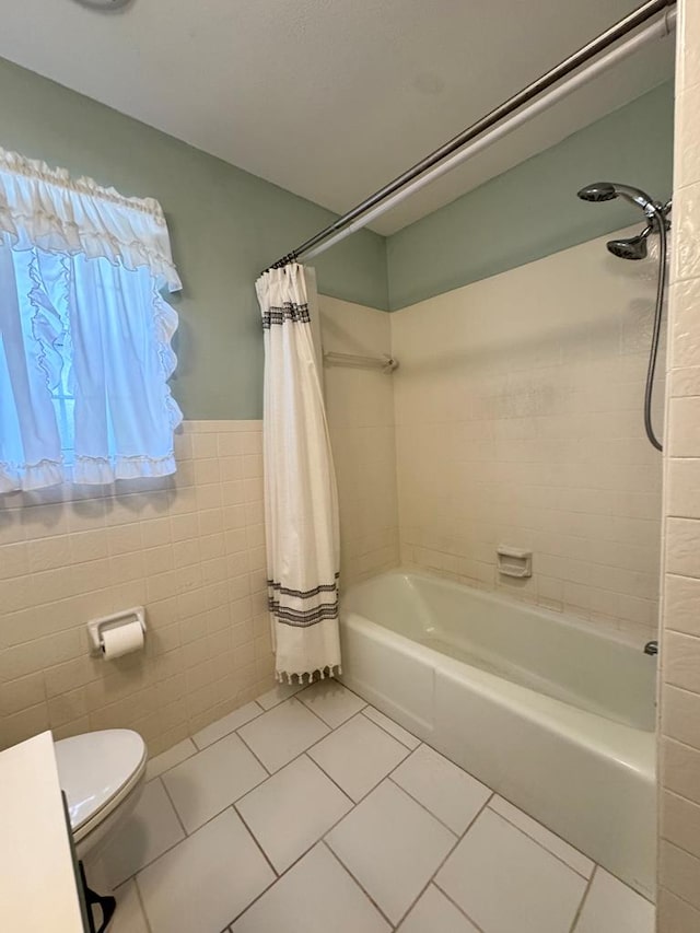 2003 N Enfield Rd, Alpine, TX 79830 - bathroom featuring tile patterned flooring, tile walls, shower / bath combo, toilet, and wainscoting