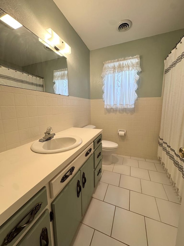 2003 N Enfield Rd, Alpine, TX 79830 - bathroom featuring tile walls, plenty of natural light, tile patterned flooring, vanity, and toilet