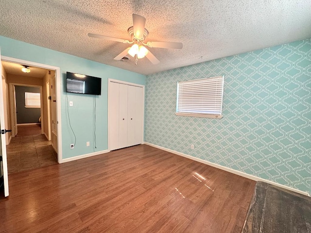 2003 N Enfield Rd, Alpine, TX 79830 - unfurnished bedroom featuring wallpapered walls, wood finished floors, a closet, baseboards, and ceiling fan