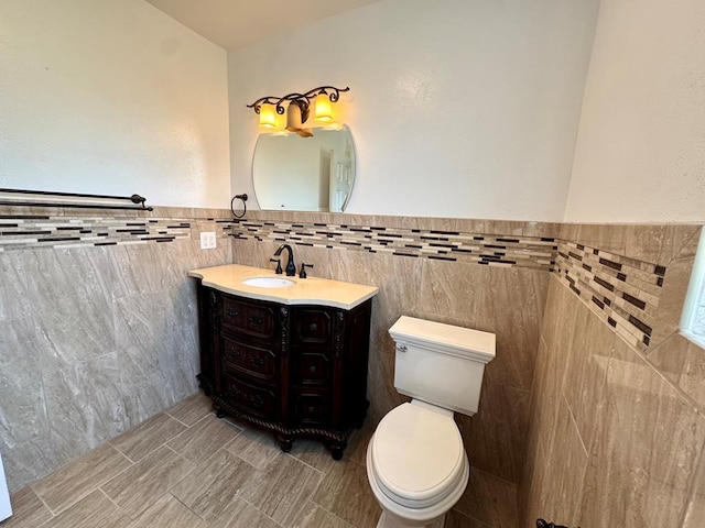 2003 N Enfield Rd, Alpine, TX 79830 - bathroom featuring tile walls, vanity, toilet, and wainscoting