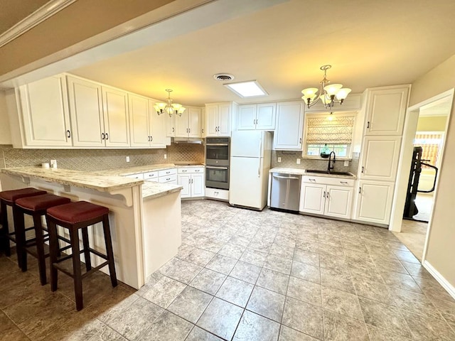 2003 N Enfield Rd, Alpine, TX 79830 - kitchen featuring a chandelier, appliances with stainless steel finishes, a sink, backsplash, and white cabinets