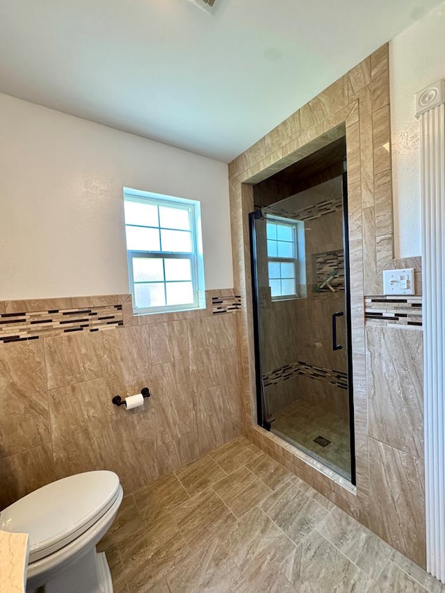 2003 N Enfield Rd, Alpine, TX 79830 - full bathroom with tile walls, a shower stall, toilet, and a wainscoted wall
