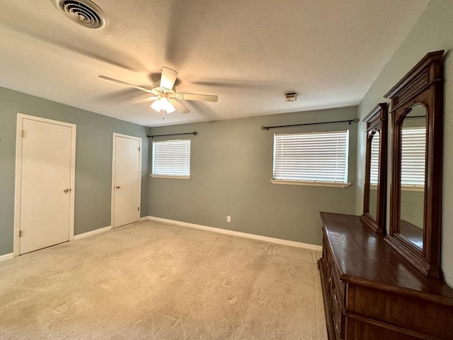 2003 N Enfield Rd, Alpine, TX 79830 - unfurnished bedroom with light colored carpet, baseboards, ceiling fan, and a textured ceiling
