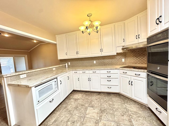 2003 N Enfield Rd, Alpine, TX 79830 - kitchen featuring double oven, white microwave, a chandelier, lofted ceiling, and tasteful backsplash