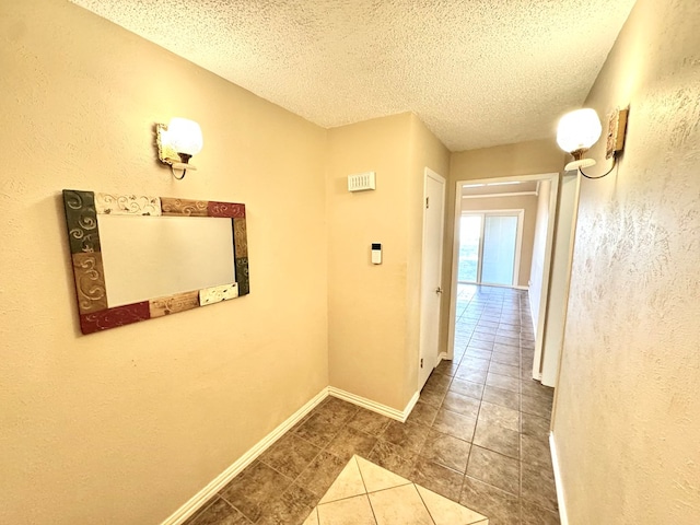 2003 N Enfield Rd, Alpine, TX 79830 - hallway featuring tile patterned floors, a textured ceiling, a textured wall, and baseboards
