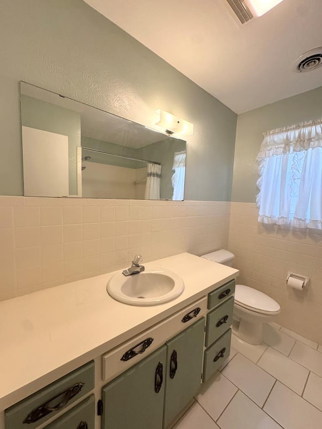 2003 N Enfield Rd, Alpine, TX 79830 - bathroom with tile walls, tile patterned floors, vanity, toilet, and curtained shower