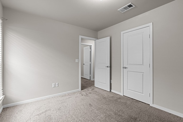 unfurnished bedroom with visible vents, carpet flooring, and baseboards