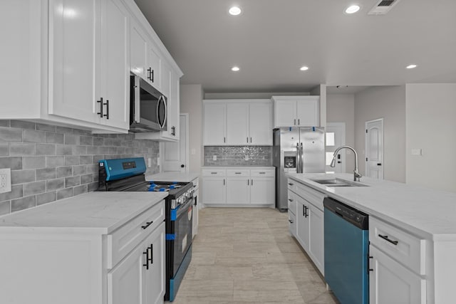 kitchen featuring visible vents, appliances with stainless steel finishes, tasteful backsplash, a sink, and white cabinetry