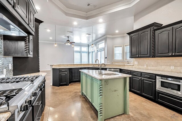 3 E Wavyleaf Ct, Odessa, TX 79762 - kitchen featuring ornamental molding, backsplash, a kitchen island with sink, ceiling fan, and a tray ceiling
