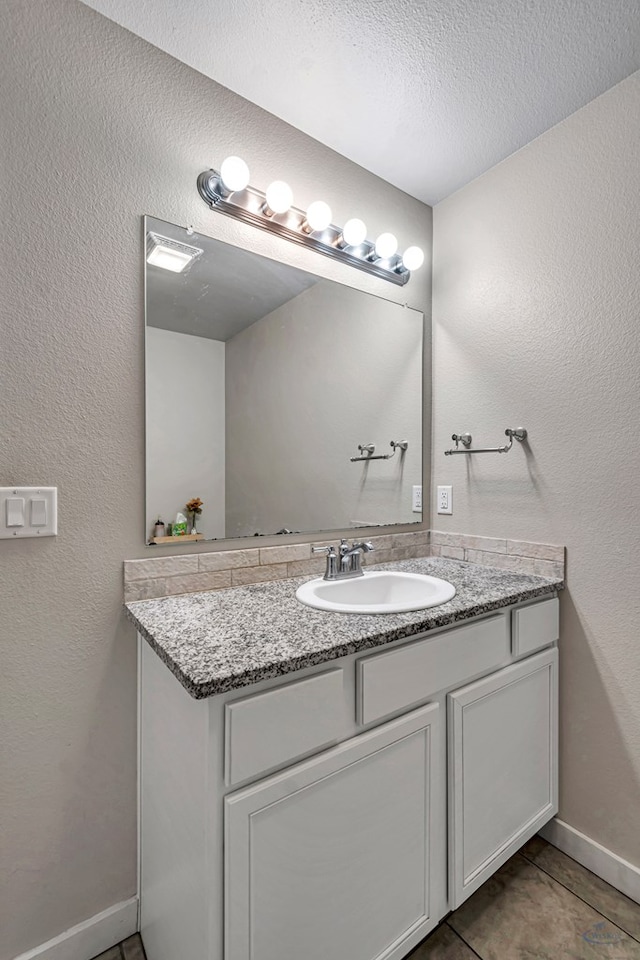 1320 E 94th St, Odessa, TX 79765 - bathroom with vanity, a textured ceiling, tile patterned flooring, and a textured wall